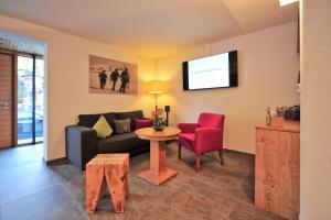 a living room with a couch and a table and a tv at Das Tannberg in Lech am Arlberg