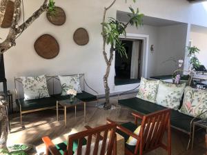 a living room with couches and a table and chairs at Vrest Hotel Otres Beach in Sihanoukville