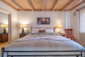 Un dormitorio con una cama grande y dos sillas. en Tahoe Pines Beach Retreat home, en Tahoe Pines