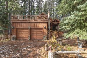una cabaña en el bosque con garaje de madera en Tahoe Pines Beach Retreat home, en Tahoe Pines