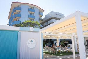 ein Gebäude mit Tischen und Stühlen vor einem Gebäude in der Unterkunft Milano Simple in Bellaria-Igea Marina