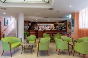 a restaurant with green chairs and a bar at Milano Simple in Bellaria-Igea Marina