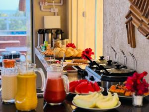 a buffet with plates of food and drinks on a table at Pousada Ybitu in São Miguel do Gostoso