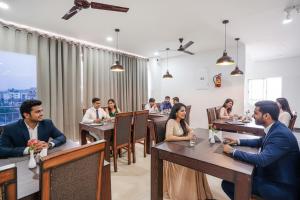 um grupo de pessoas sentadas às mesas de um restaurante em Via RLV Green Palace - Nr Kengeri Satellite Town em Bangalore