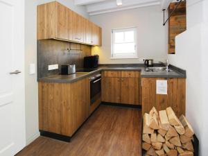 a kitchen with wooden cabinets and a counter top at Semi-detached houses, turf house in Torfhaus