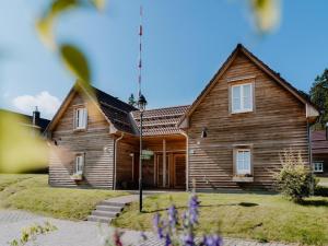 a wooden house is shown with flowers in front of it at Semi-detached houses, turf house in Torfhaus