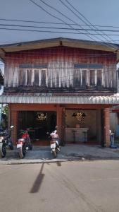 twee motorfietsen geparkeerd voor een gebouw bij Baan Chok Dee Homestay in Chiang Khan