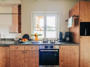 a kitchen with wooden cabinets and a stove top oven at Semi-detached houses, turf house in Torfhaus +75 photos
