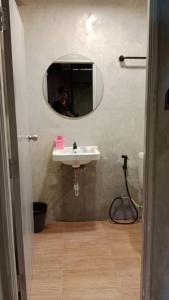 een man die een foto neemt van een badkamer met een wastafel bij Baan Chok Dee Homestay in Chiang Khan