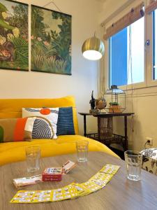 un soggiorno con un divano giallo e un tavolo di Sweet Jungle - Stylish, Cozy and Romantic - Colmar a Bollwiller