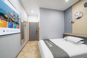 a small room with a bed and a painting on the wall at Shanghai Grand View Hotel in Shanghai