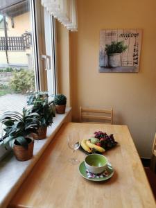 een houten tafel met een fruitschaal en een kopje koffie bij Ferienhaus Enger in Beulwitz +10 foto's