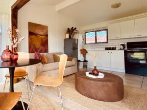 a living room with a couch and a table at Sandpiper Cottage in Fish Hoek +15 photos