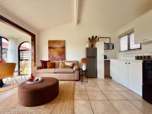 a living room with a couch and a table at Sandpiper Cottage in Fish Hoek