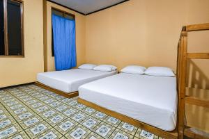 duas camas em um quarto com dinheiro em Villa TB Pangalengan Bandung RedPartner em Palayangan