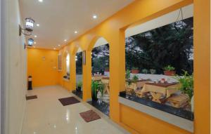 ein Flur mit gelben Wänden und ein Esszimmer mit Tischen in der Unterkunft The Boho Cochin in Kochi
