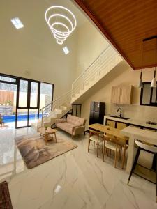 uma grande sala de estar com uma cozinha e uma escadaria em Sierra Villa Malang - Private Swimming Pool - 4 BR em Ngadipuro