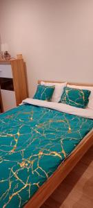 uma cama com um edredão verde e almofadas em Nastaran Nest em Oberhausen mais 6 fotografias