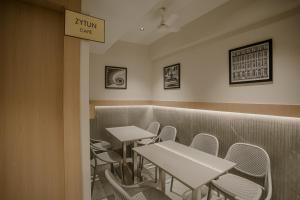 Un comedor con mesas y sillas y un cartel que dice Jump Cafe. en Metropolis Business Hotel, en Panaji