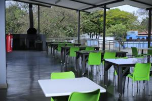 an empty cafeteria with tables and green chairs at Green Side accommodation in Rustenburg