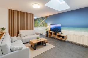 a living room with a couch and a tv at Ideal for Big Groups, Modern 14 Guest Apartment Near Prague in Rakovník