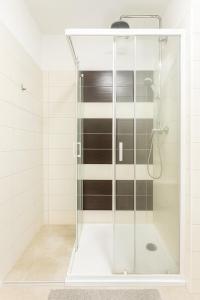 a shower with a glass door in a bathroom at Ideal for Big Groups, Modern 14 Guest Apartment Near Prague in Rakovník