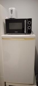um micro-ondas sentado em cima de um frigorífico branco em Nastaran Nest em Oberhausen