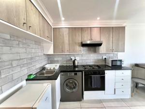 a kitchen with a washing machine and a sink at Sea la vie at Jbay in Jeffreys Bay