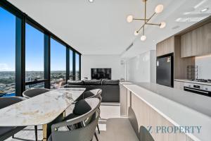 an open kitchen with a long counter and chairs at Bright & Spacious 2BR in Prime CBD Location in Perth