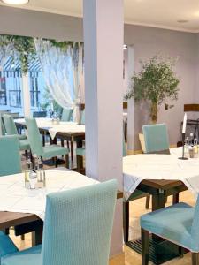 ein Esszimmer mit Tischen und blauen Stühlen in der Unterkunft Pensiunea Vila Chesa in Corunca