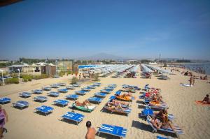 een groep mensen op een strand bij Sabbie dell'Etna - Eleganza e Comfort nel Cuore di Catania con Parcheggio Privato in Catania