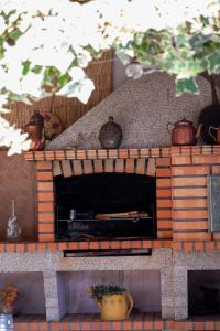 a brick fireplace with pots on top of it at Casa Flor do Campo in Celorico de Basto