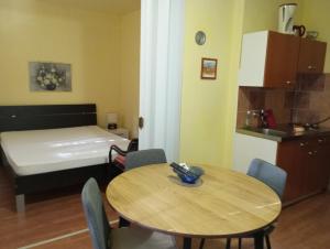 a small room with a table and a bed and a kitchen at villa Adriana apartments in Rab