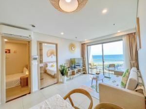 头顿The Sóng Vũng Tàu Infinity Pool Apartment - Hồ Bơi Vô Cực的带沙发的客厅和美景卧室