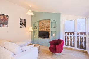 L'Allobroge - Charme & confort au cœur de Vienne في فيين: غرفة معيشة مع أريكة وكرسي احمر