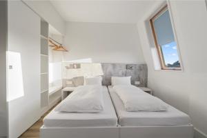 ロンドンにあるmk hotel londonの窓のある白い部屋にベッドが2つある