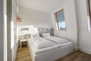 ロンドンにあるmk hotel londonのベッドと窓のある白い寝室 +15枚の写真