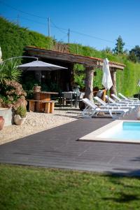 a group of lounge chairs and a swimming pool at Casa Flor do Campo in Celorico de Basto