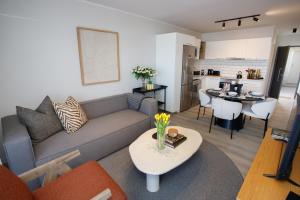 克尼斯纳302 Seahorse - Premium 2 Bedroom Unit with Pool & Parking的客厅里有一张沙发和一张桌子。