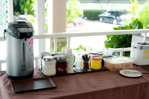a coffee maker sitting on a table next to a window at Chiangkham Grand Villa - SHA Certified in Chiang Kham