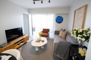 克尼斯纳302 Seahorse - Premium 2 Bedroom Unit with Pool & Parking的客厅里有一张沙发和一台电视