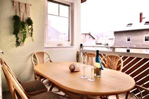 a wooden table with a bottle and glasses on a balcony at Ganswoanders - deine kleine Beach Oase am Traunsee in Gmunden +34 photos