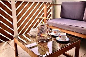 a coffee table with two cups and a vase at Ganswoanders - deine kleine Beach Oase am Traunsee in Gmunden