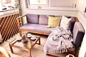 a purple couch on a balcony with a table at Ganswoanders - deine kleine Beach Oase am Traunsee in Gmunden