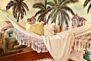 a hammock with pillows in a room with palm trees at Ganswoanders - deine kleine Beach Oase am Traunsee in Gmunden