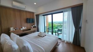 ein Hotelzimmer mit einem Bett und einem großen Fenster in der Unterkunft โรงแรมม่านฟ้า in Ban Na Tho