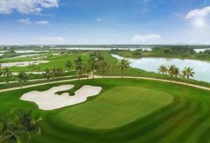 an overhead view of a green golf course with a lake at The Hanok Hotel Do Son in Hai Phong