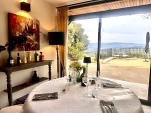 a dining room with a table and a large window at La Villa des Cedres in Bonnieux
