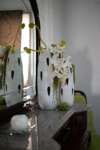 three white vases sitting on a table in front of a mirror at Casa Flor do Campo in Celorico de Basto