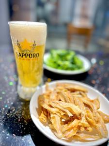 a table with two plates of food and a glass of beer at The Hanok Hotel Do Son in Hai Phong +27 photos
